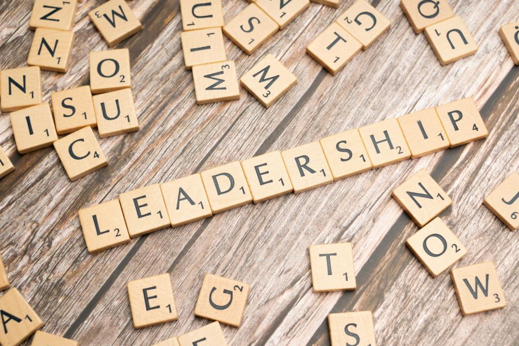 Wooden letter tiles spelling 'LEADERSHIP' on a wooden surface, symbolizing leadership qualities and skills.